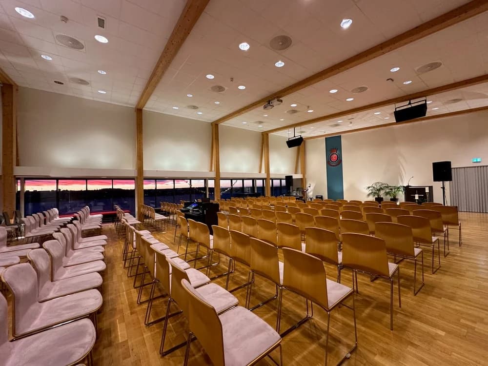 Korpssalen med stoler, lerret og konferanseoppsett.